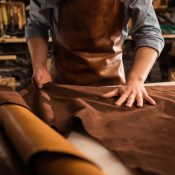 Close up of a cobbler working with leather textile at his workshop